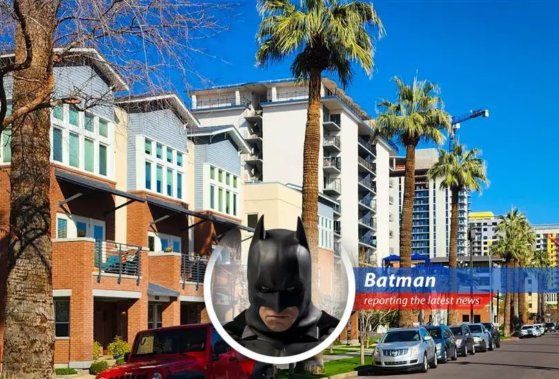 Gotham City skyline with a looming shadow, symbolizing the economic pressures affecting housing.