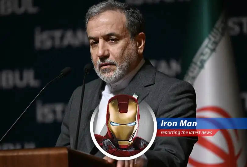 Tony Stark, aka Iron Man, contemplates global peace strategies from his workshop.