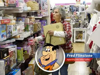Fred Flintstone ponders the stock market while Wilma rolls her eyes.
