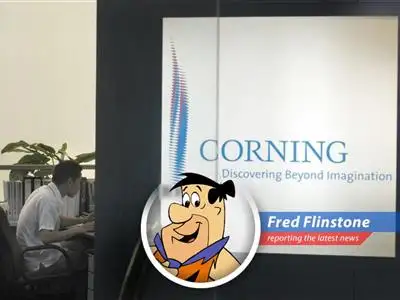 Fred Flintstone ponders the stock market, wondering if he should invest his hard-earned clams in dinosaur-powered technology.